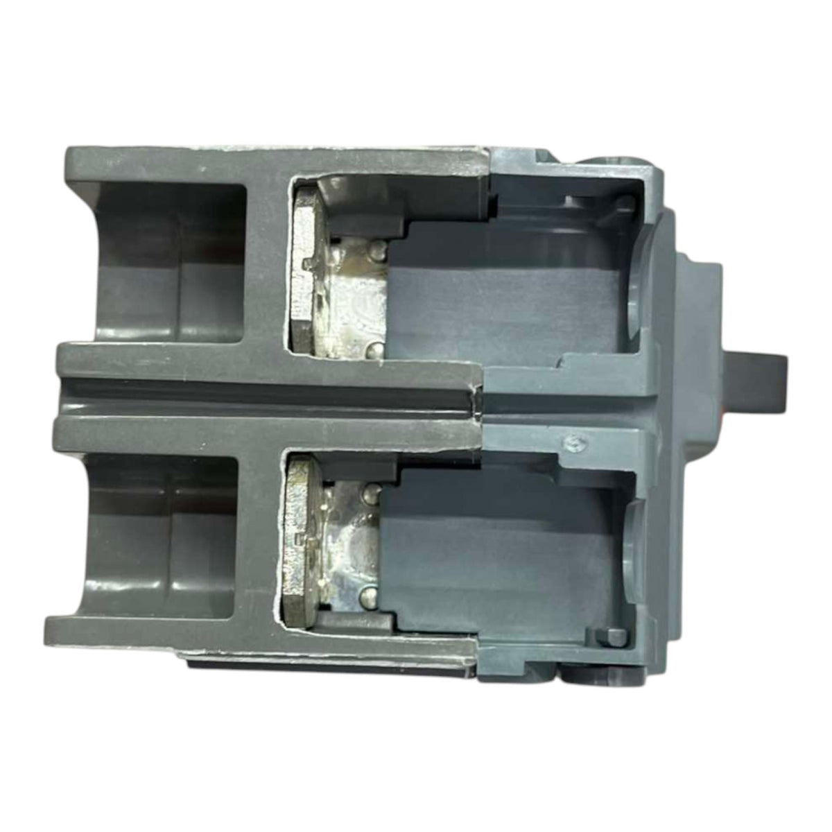 A gray plastic mechanical component or pump housing with a cutaway view showing internal metal and plastic parts, isolated on a white background.