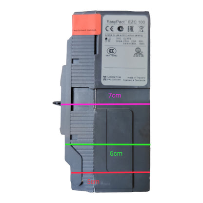 A gray industrial electrical module with a white label and an orange top tab, shown on a white background with overlaid dimension lines and text reading 7cm, 6cm, and 5cm.