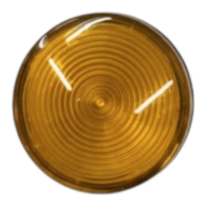 A circular amber-colored plastic lens or cover with concentric circular ridges and two bright white light reflections, shown on a plain white background.
