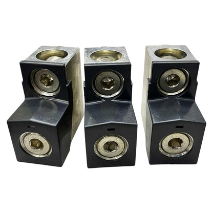 Three black metal blocks with brass-colored circular components on a white background