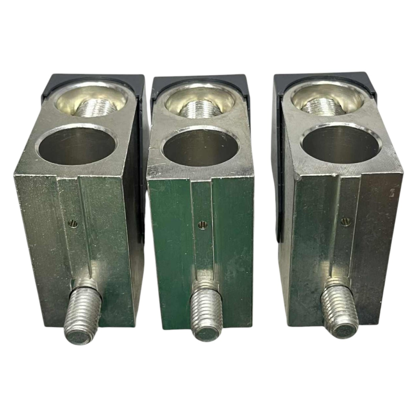 Three metal blocks with cylindrical holes and threaded rods on a white background