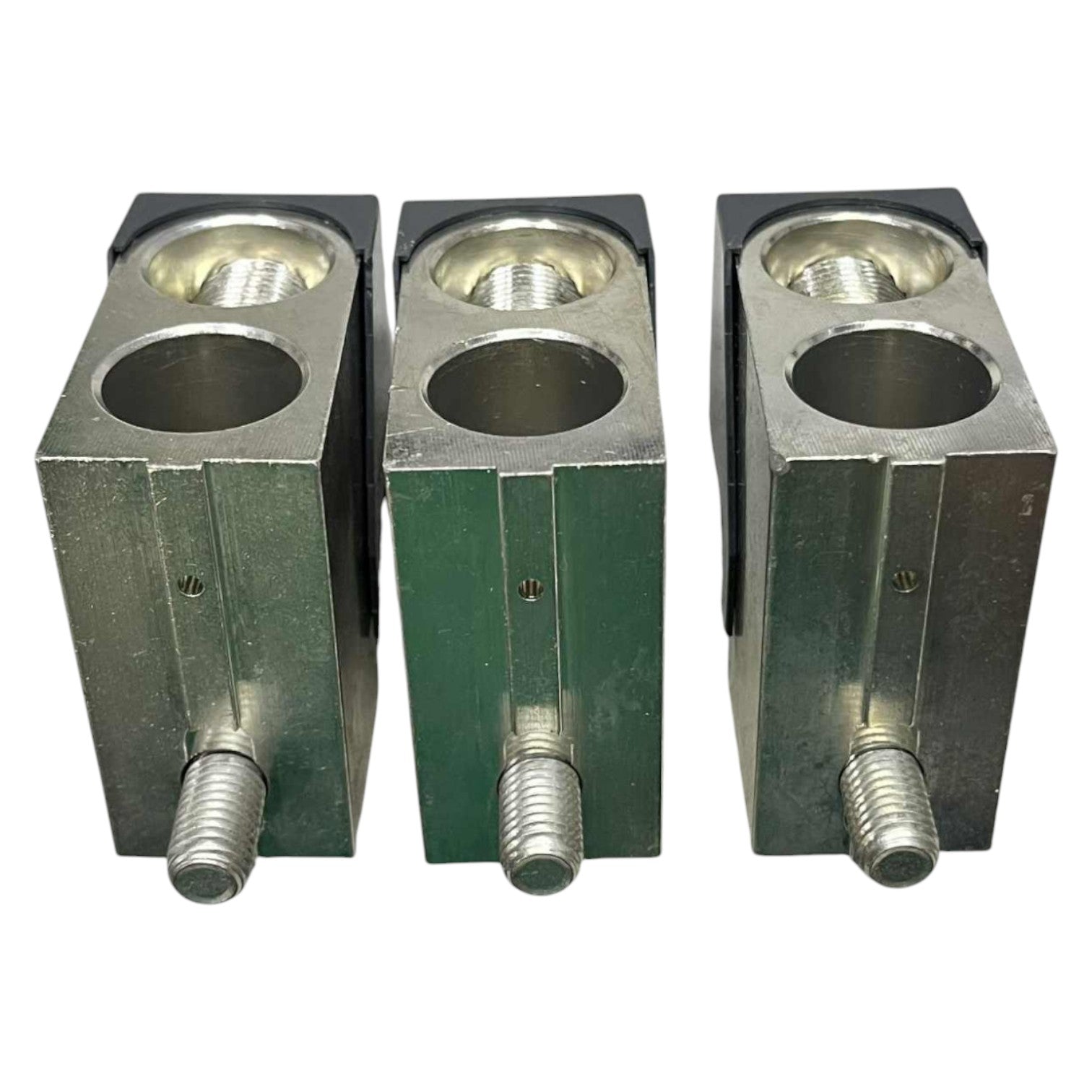 Three metal blocks with cylindrical holes and threaded rods on a white background