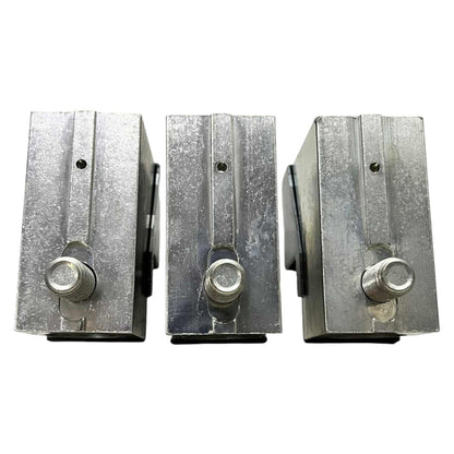 Three metallic blocks with cylindrical components on a white background