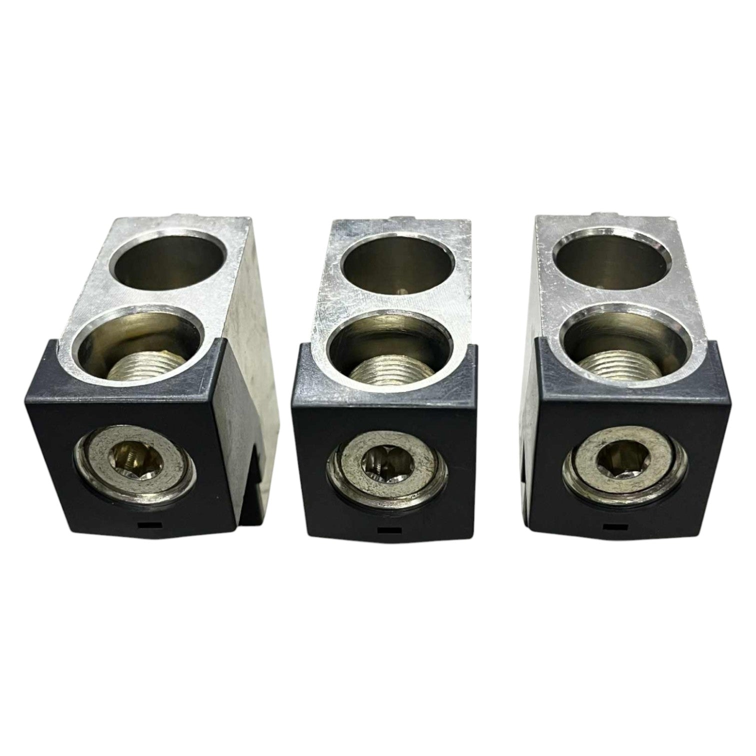 Three metallic block components with threaded holes on a white background