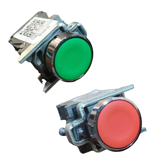 Two industrial push-button switches shown on a plain white background, one with a green button face and one with a red button face, both with metal housing and a small label sticker.
