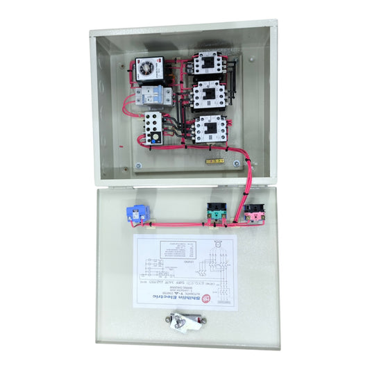 An open industrial electrical control panel box showing internal components including contactors, a thermal overload relay, and wiring, with the lower door displaying a technical diagram sheet and small hardware.