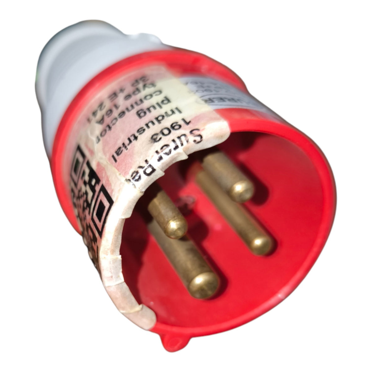 A close-up of a red and white industrial electrical plug connector with three brass pins visible inside, shown on a plain white background.