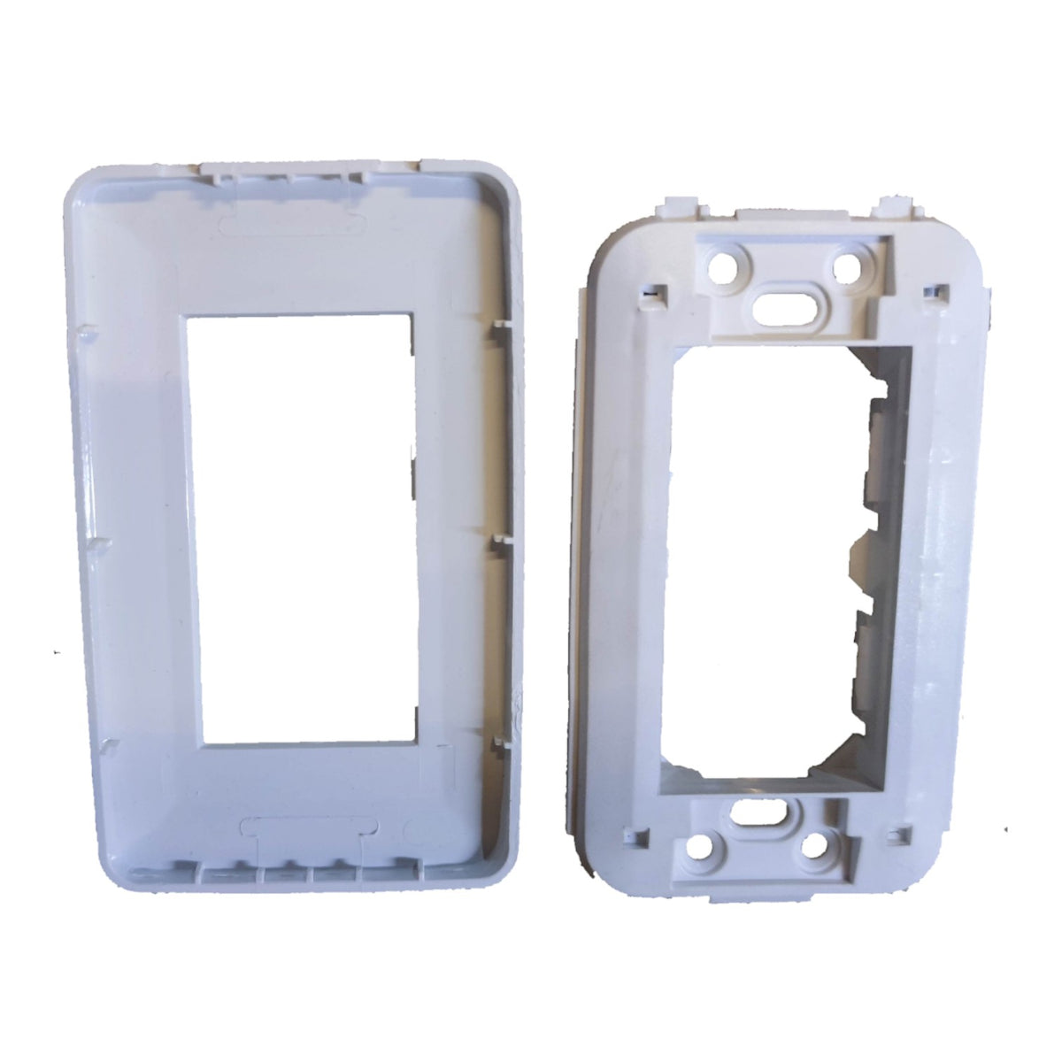 Two white plastic electrical outlet or switch plate frames shown on a plain white background, one with a rectangular center cutout and one with a different shaped cutout and mounting holes.