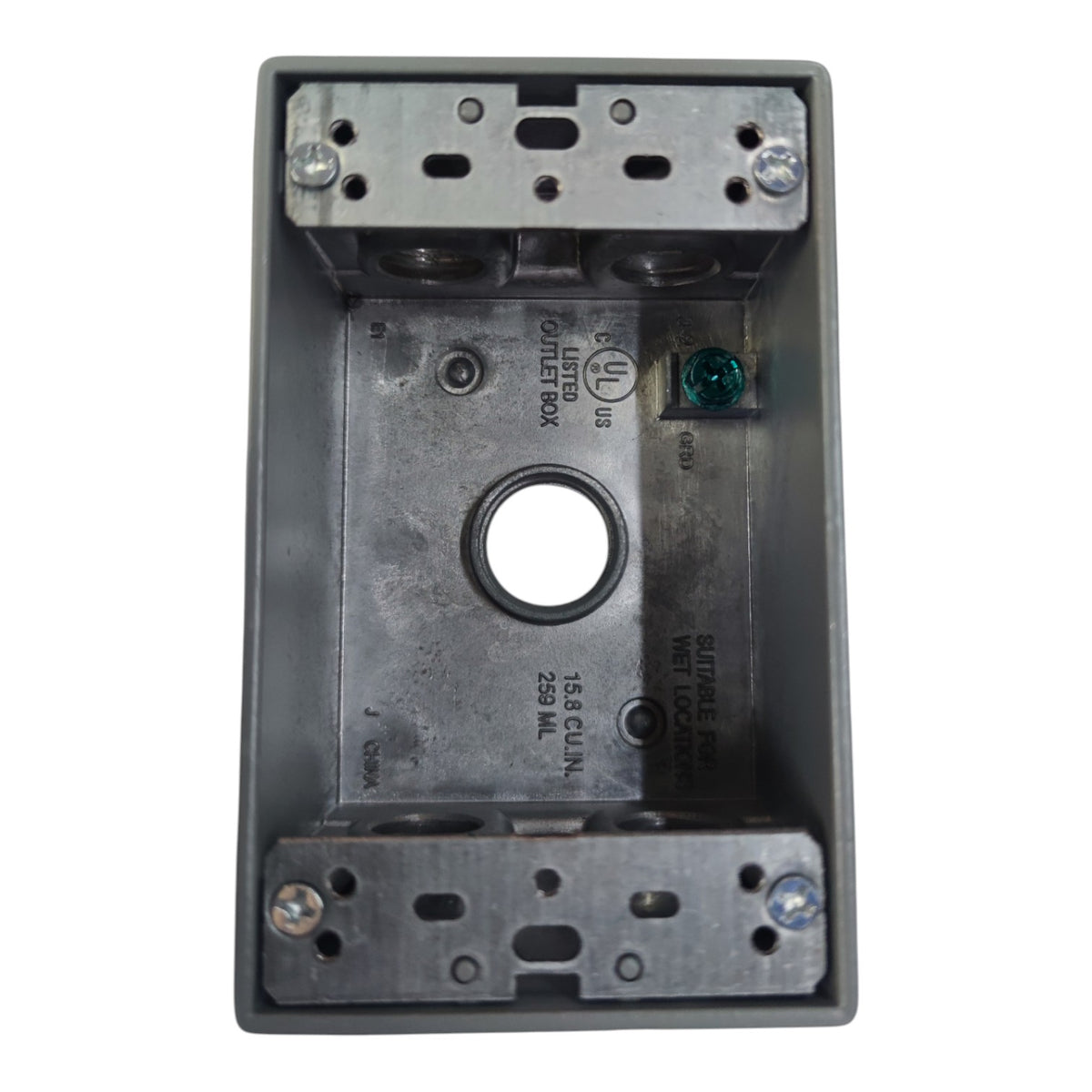 A gray metal electrical junction box with a central circular opening, pre-drilled screw holes, and printed technical specifications on the inner surface, isolated on a white background.