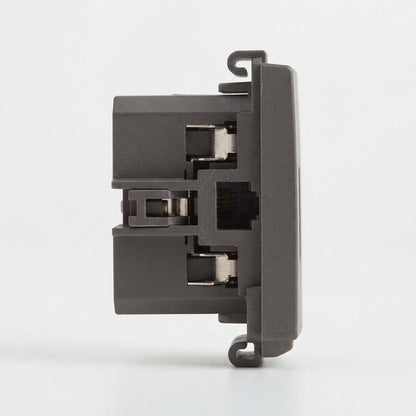 A close-up side view of a dark gray plastic electronic component or connector module on a clean white background.
