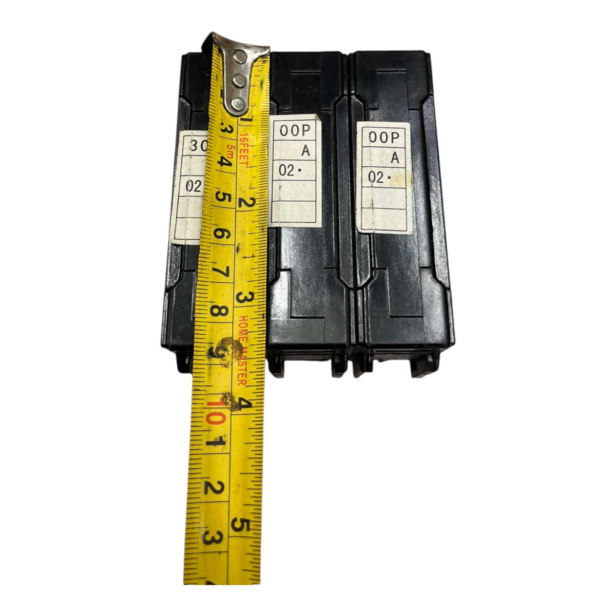 Two black electrical contactors with white identification labels, shown next to a yellow tape measure to indicate size on a white background.