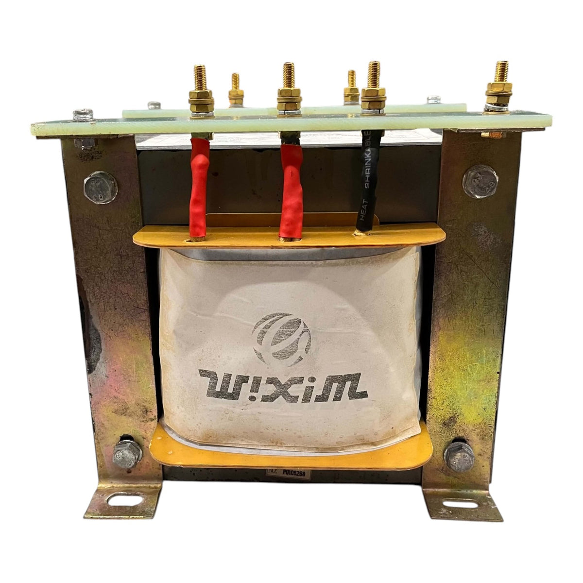 A heavy-duty industrial electrical transformer with a white paper core wrapped in gray protective tape featuring the 'WIXIM' brand logo. The top and bottom sections are constructed from weathered galvanized steel with brass terminal bolts, and the core is supported by yellow insulating spacers.