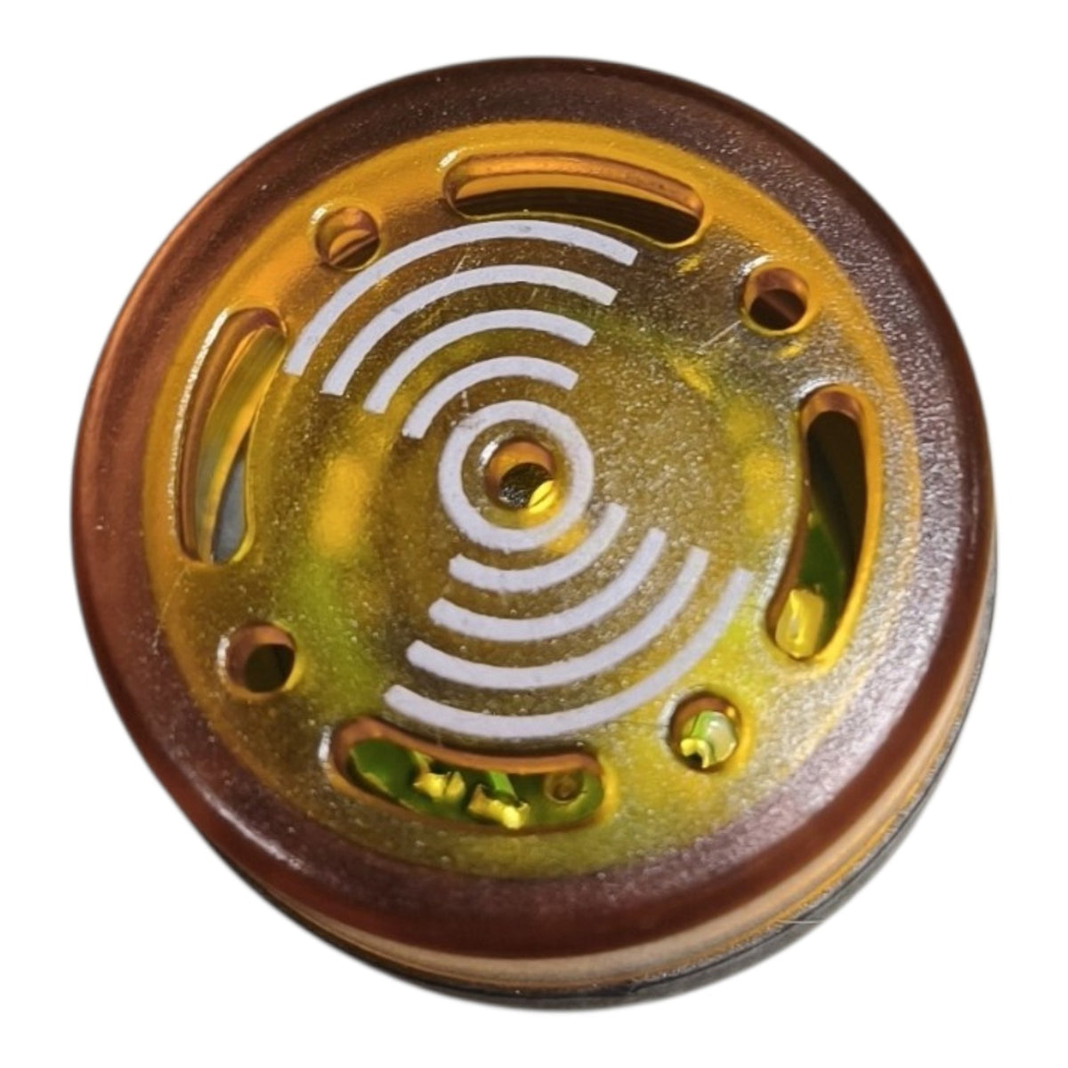 A round amber-brown and translucent gold plastic component with white concentric arc markings and several cutouts, shown on a plain white background.