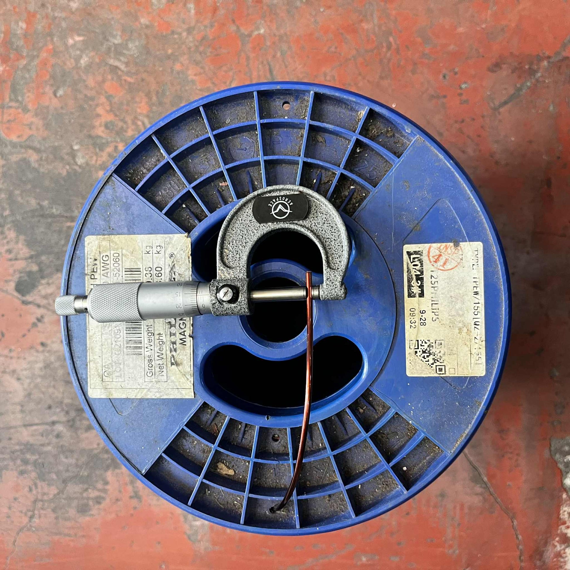 Philflex AWG 10 magnet wire for transformers on blue spool with a measuring tool