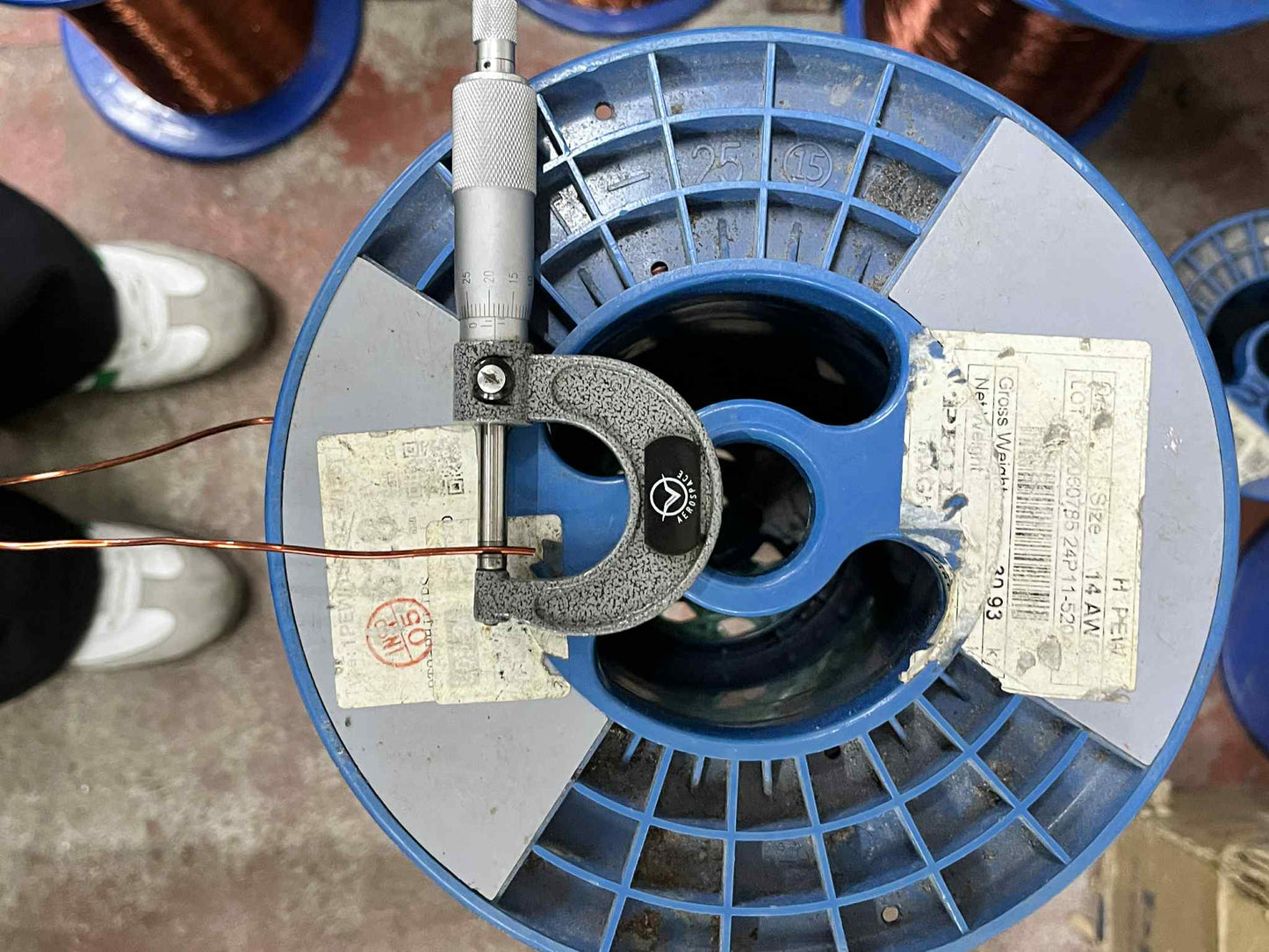 Philflex AWG 14 magnet wire on a blue spool with measuring tool for quality assurance