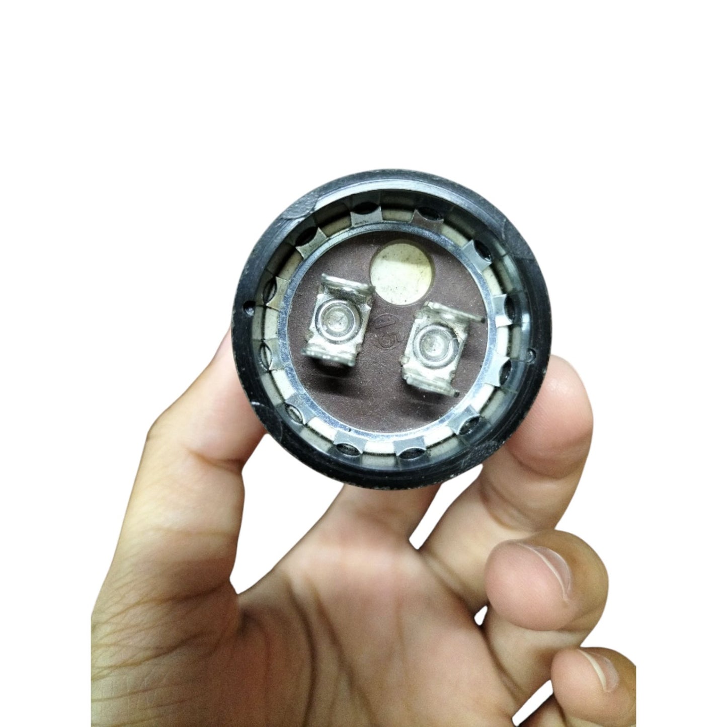 Hand holding a 233-280uF Motor Starting Capacitor with metal terminals for reliable electrical performance