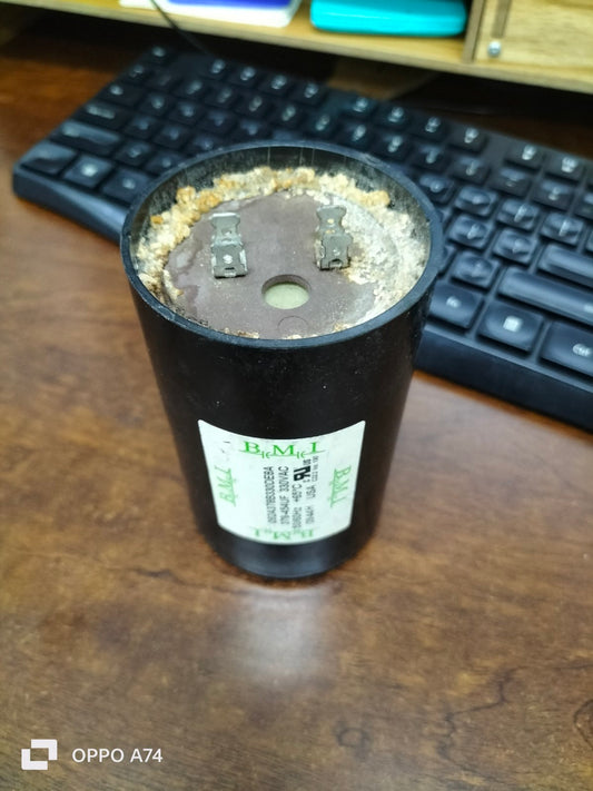 BMI 378-454UF starting capacitor black cylindrical electrical component on wooden desk