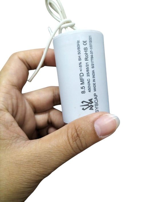 Syscap 8.5MFD 450 VAC Running Capacitor held in hand with white cylindrical body and wires