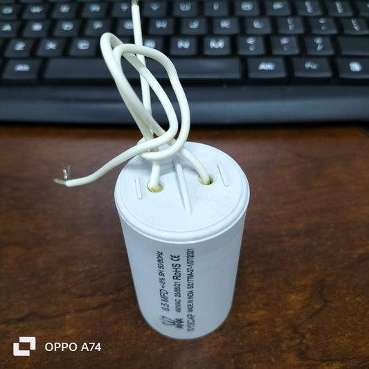Syscap 8.5MFD 450 VAC Running Capacitor white cylindrical with attached wires on wooden surface