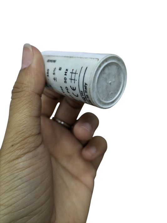 Commar 3.5uF motor run capacitor held in hand with white cylindrical body and printed specifications