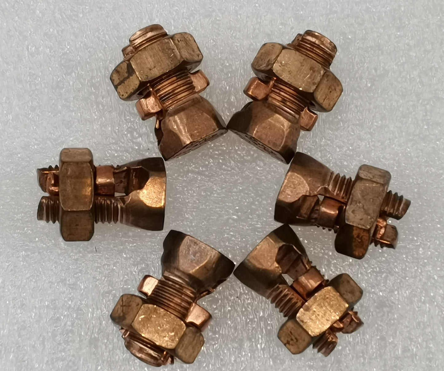 Six copper Solderless Connector 1 Bolt 8-22MM cable clamps arranged on white foam for electrical circuitry parts