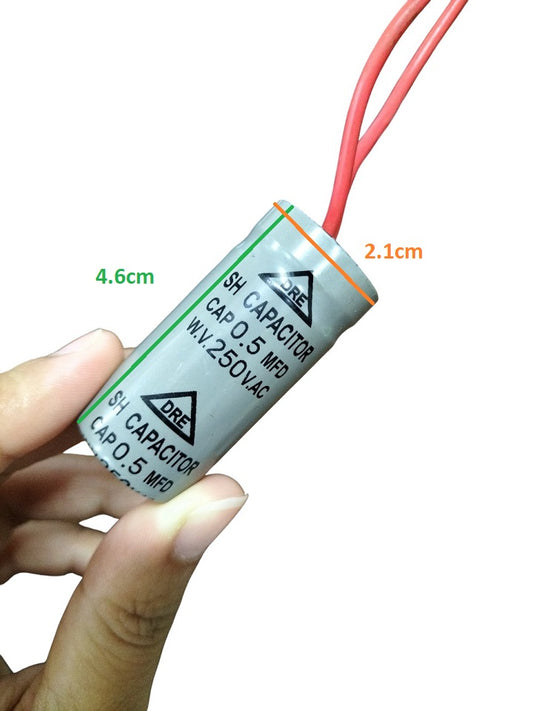DRE 0.5MFD Motor Running Capacitor with red wires held between fingers showing compact size