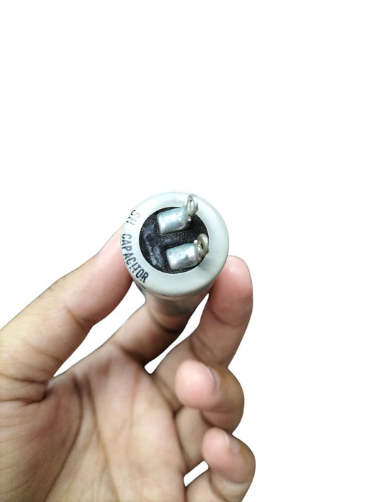 DRE 0.5MFD Motor Running Capacitor held in hand showing terminals and cylindrical body