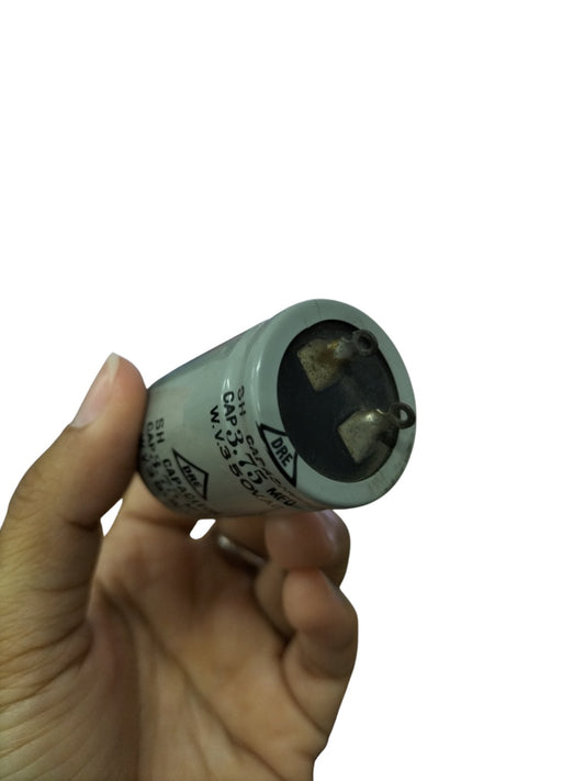 DRE 3.75 MFD motor running capacitor held in hand for electrical circuitry and parts