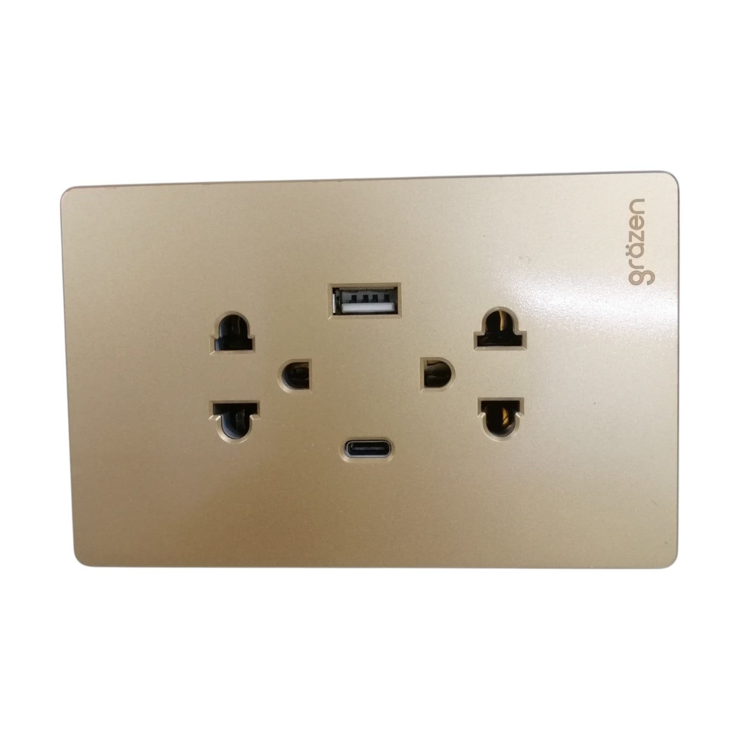 A gold-colored wall outlet cover plate featuring a USB-C port and a standard USB-A port, with the brand name 'grdzen' printed on the top right.