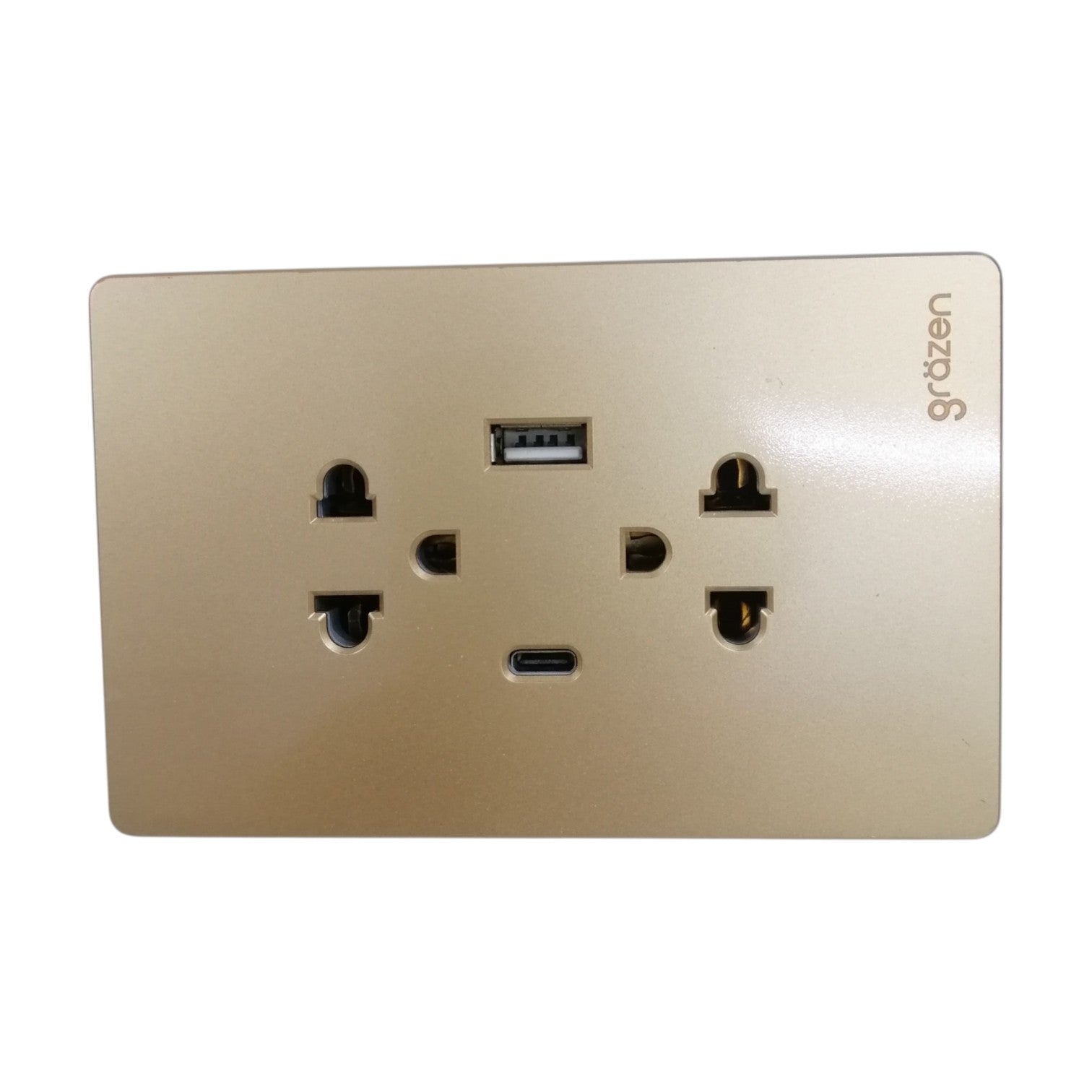 A gold-colored wall outlet cover plate featuring a USB-C port and a standard USB-A port, with the brand name 'grdzen' printed on the top right.