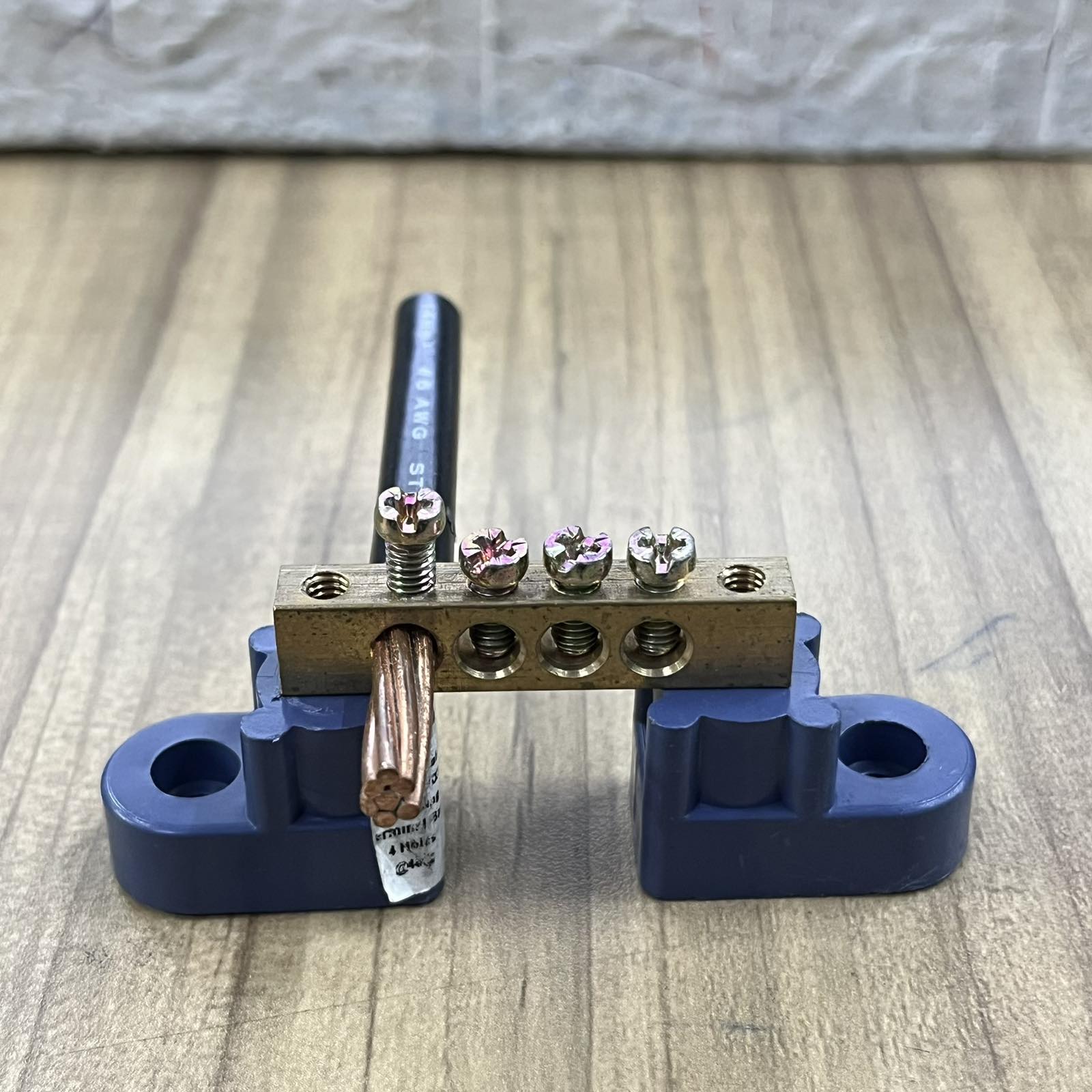 Grippes Electrical Grounding Bus Bars 4 Holes with screws and copper wire mounted on blue base