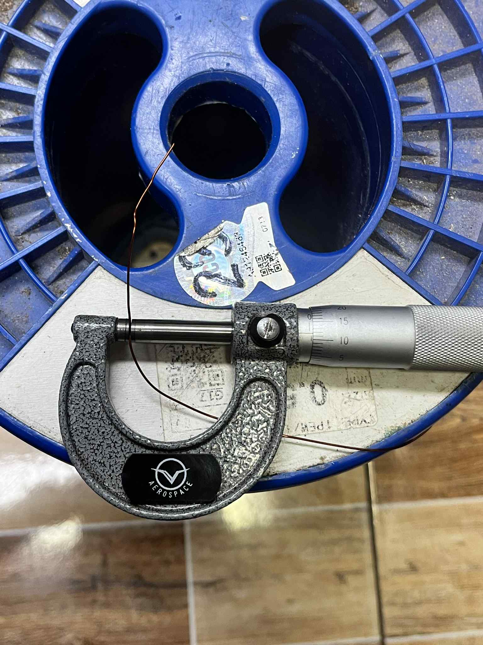 Micrometer measuring Heavy Formix magnet wire AWG 23 900G on a blue spool