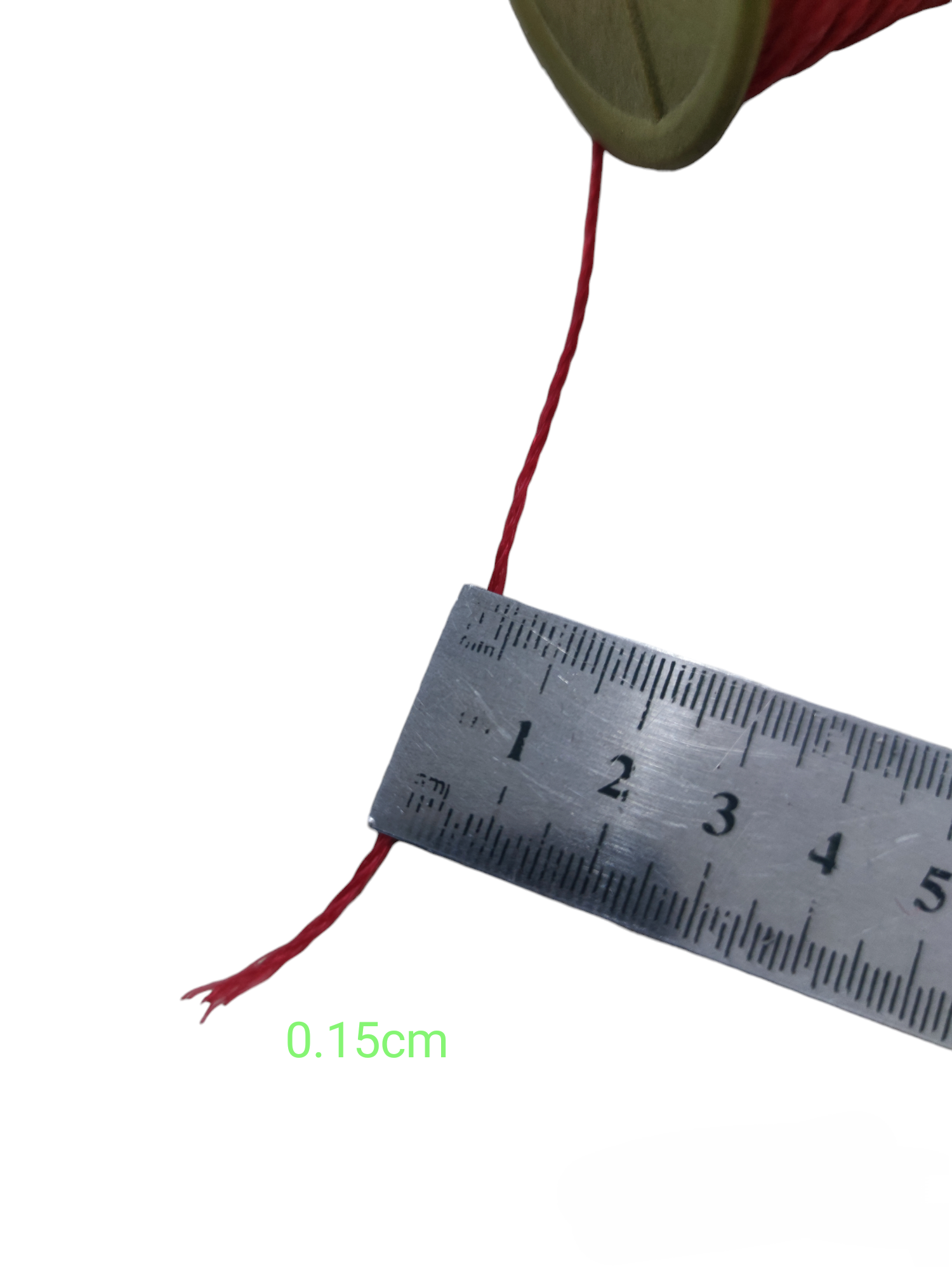 Close-up of industrial nylon rope spool red with a measuring ruler showing 0.15cm thickness
