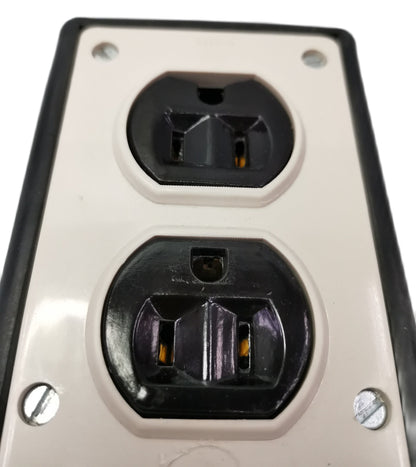 Kopez 4 gang rubber electrical outlet with two black plug sockets on white panel