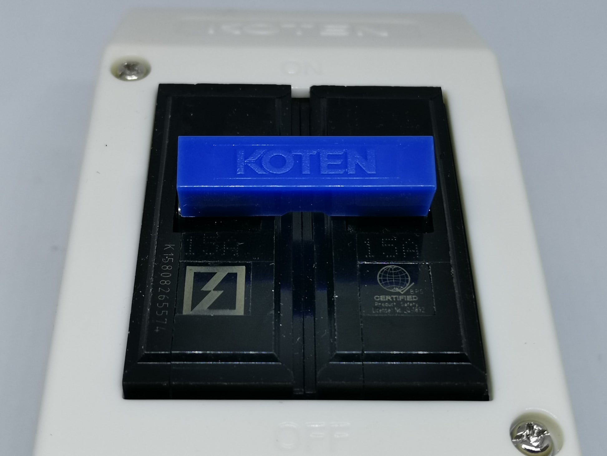 Koten 15A circuit breaker with outlet featuring black switches and blue toggle handle in white casing