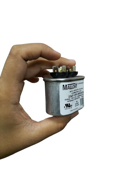 Mallory 440V running capacitor held in hand with clear label and connection terminals visible