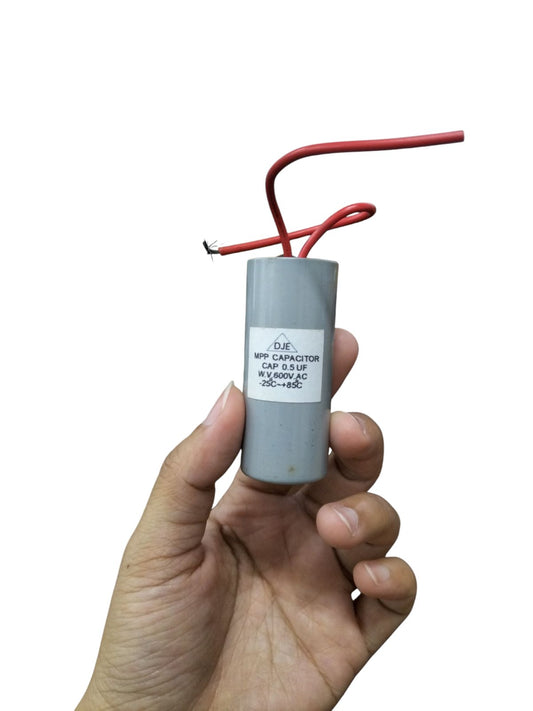 DJE motor capacitor with red wires held for electrical applications