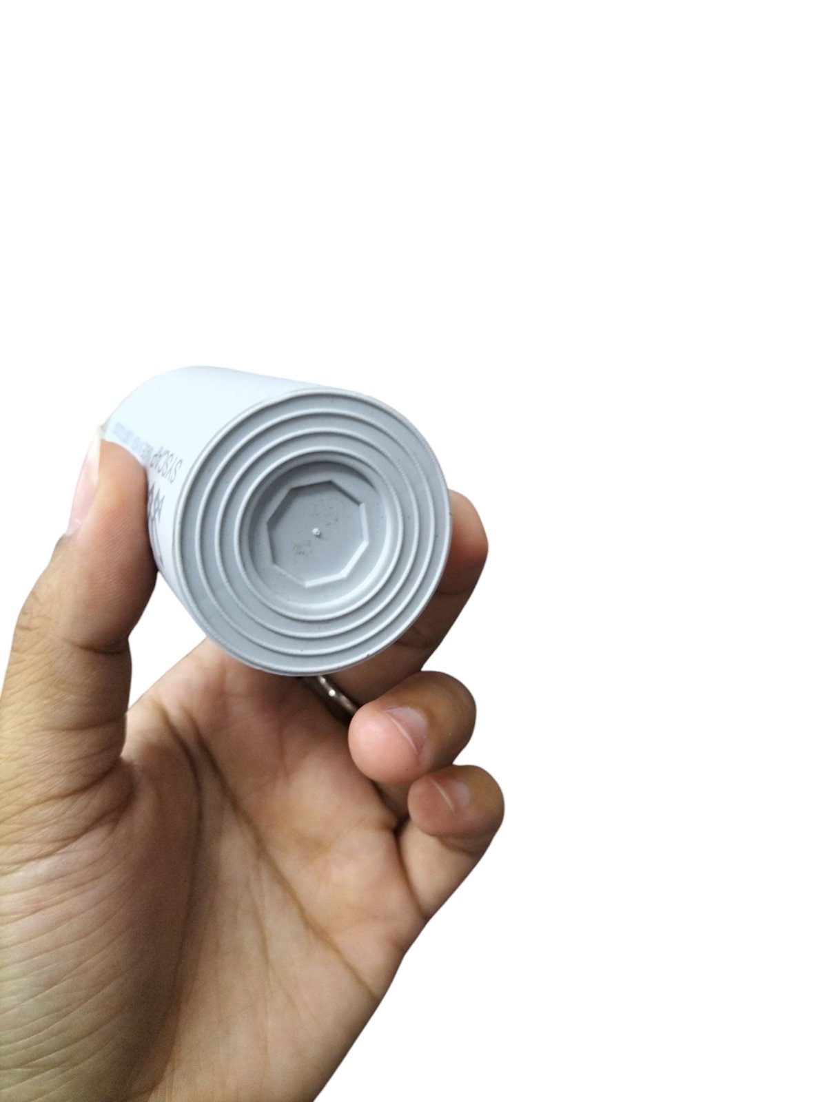 Syscap 70MFD 250V motor capacitor held in hand showcasing its cylindrical design