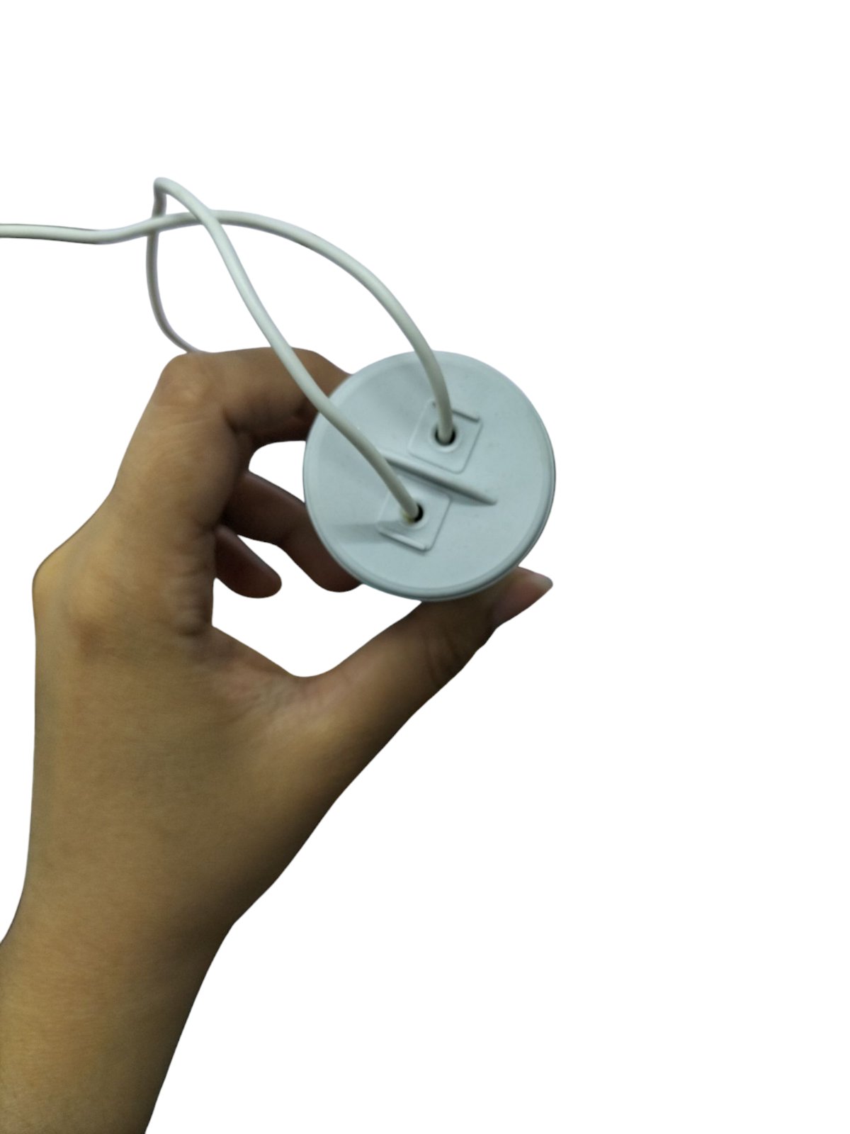 Hand holding a Syscap 70MFD 250V motor capacitor with two wires for electrical circuits