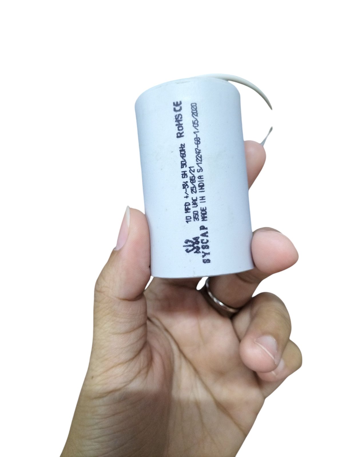 Syscap 10MFD Motor Running Capacitor held in hand, designed for enhancing motor efficiency