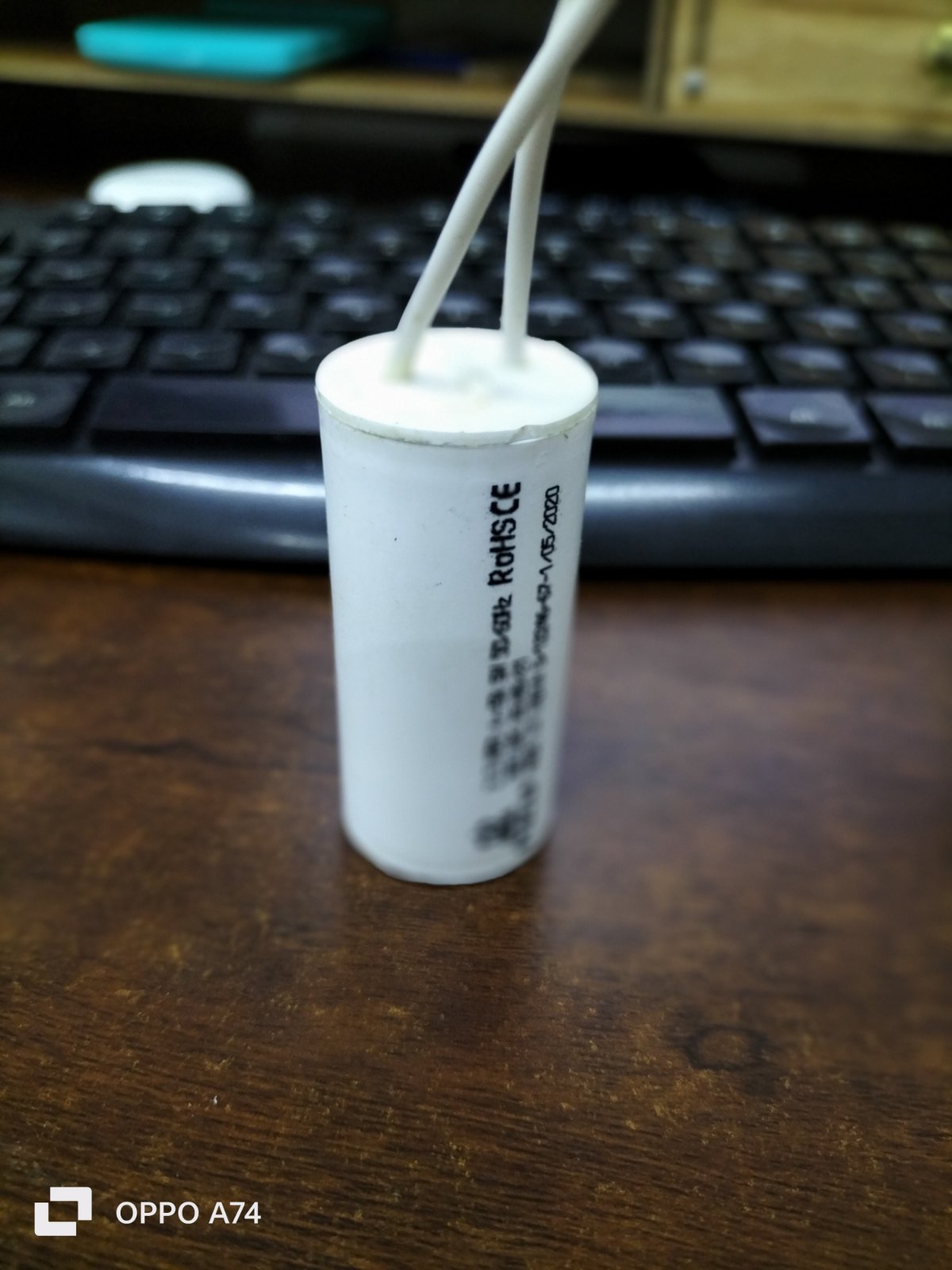 Syscap Motor Running Capacitor 2.5MFD white cylindrical electrical component with wires on wooden surface