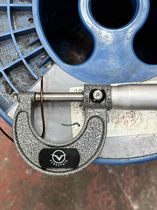 Philflex magnet wire AWG 16 being measured with a digital micrometer on a blue spool