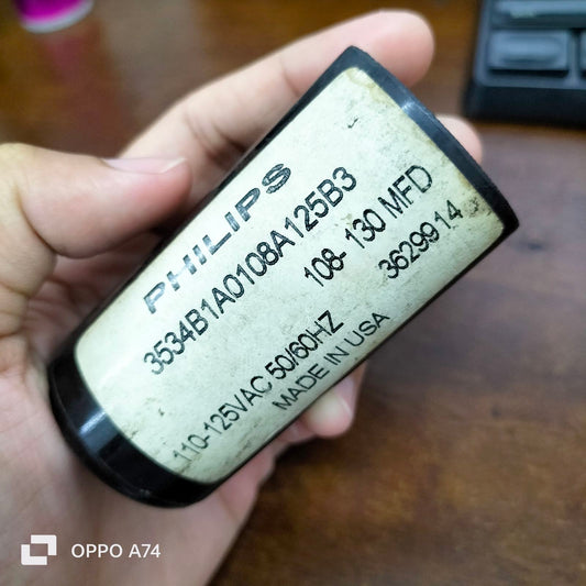 Philips Starting Capacitor 108-130 MFD held in hand for electrical circuitry and parts