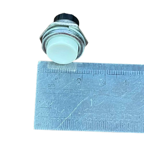 Round Push Button 1A 220V White shown with a ruler for size reference