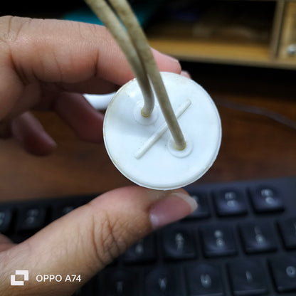 Close-up of SYSCAP 1.5 microfarad capacitor held by hand showing white cylindrical electrical part with attached wires