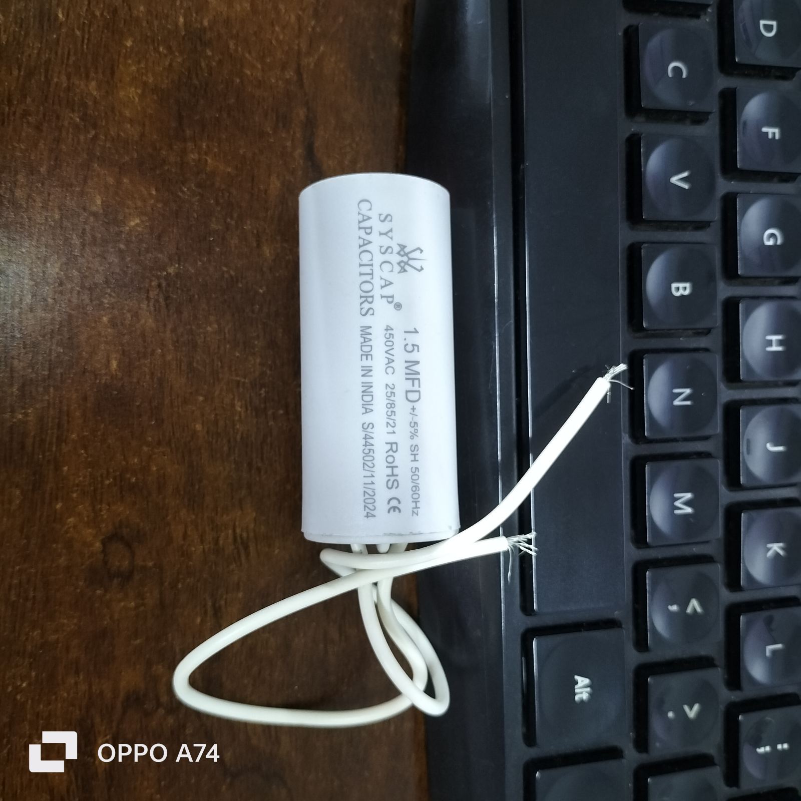 Syscap 1.5MFD 450V AC Motor Run Capacitor white cylindrical electrical component near keyboard