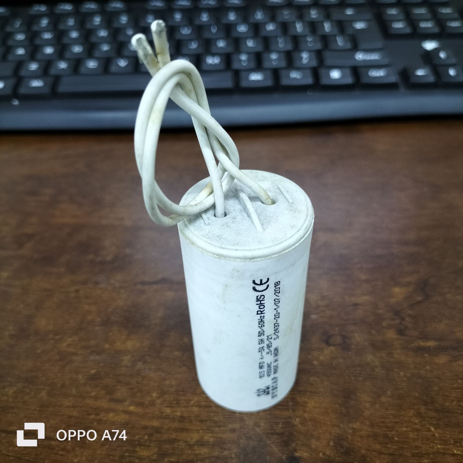 Syscap 10.5MFD 450 VAC Running Capacitor white cylindrical electrical component with wires on wooden table
