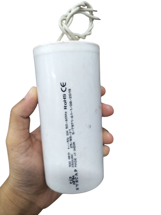 Hand holding SYSCAP 100MFD 250V AC Motor Running capacitor electrical part in white casing