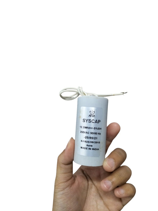Hand holding Syscap 12.5MFD 250 VAC Running Capacitor white cylindrical electrical part