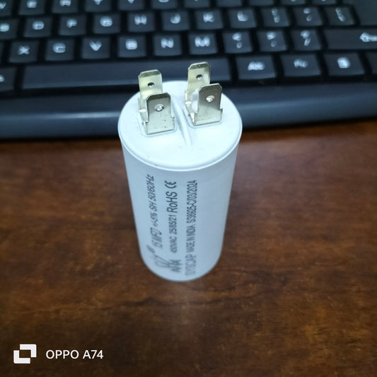 Syscap 15MFD motor running capacitor with metal terminals on brown surface near keyboard